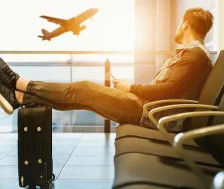Photo d'un homme attendant à l'aéroport le départ de son avion pour aller fêter un EVG/EVJF à l'étranger
